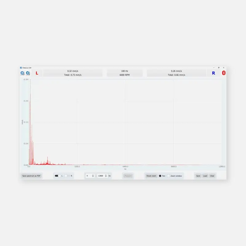Computer screen showing VMI XBalancer+ vibration spectrum graph with red spikes.