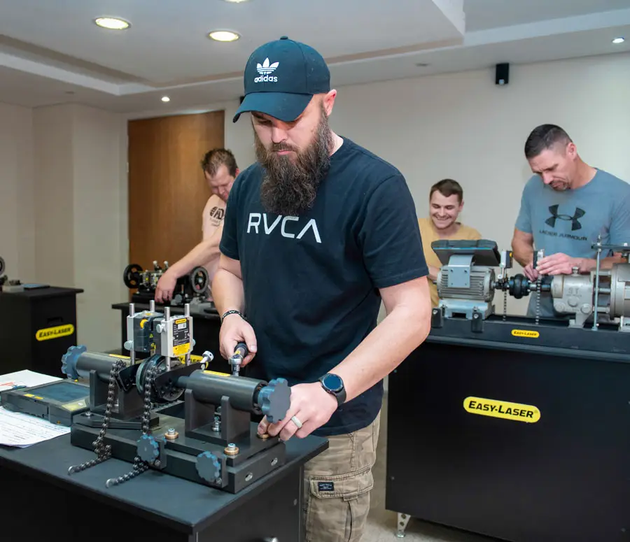 Four men in a well-lit room participate in Easy-Laser shaft alignment training.