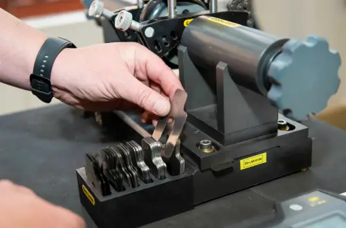 “Hand selecting shim from precision measuring set”