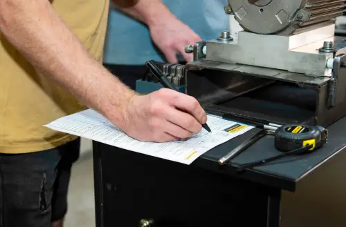 “Technician recording measurements on workshop checklist”