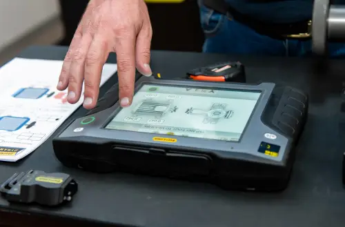 “Technician using handheld diagnostic tablet displaying VESA schematic”