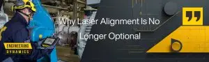 Technician using tablet for laser alignment beside industrial machinery.